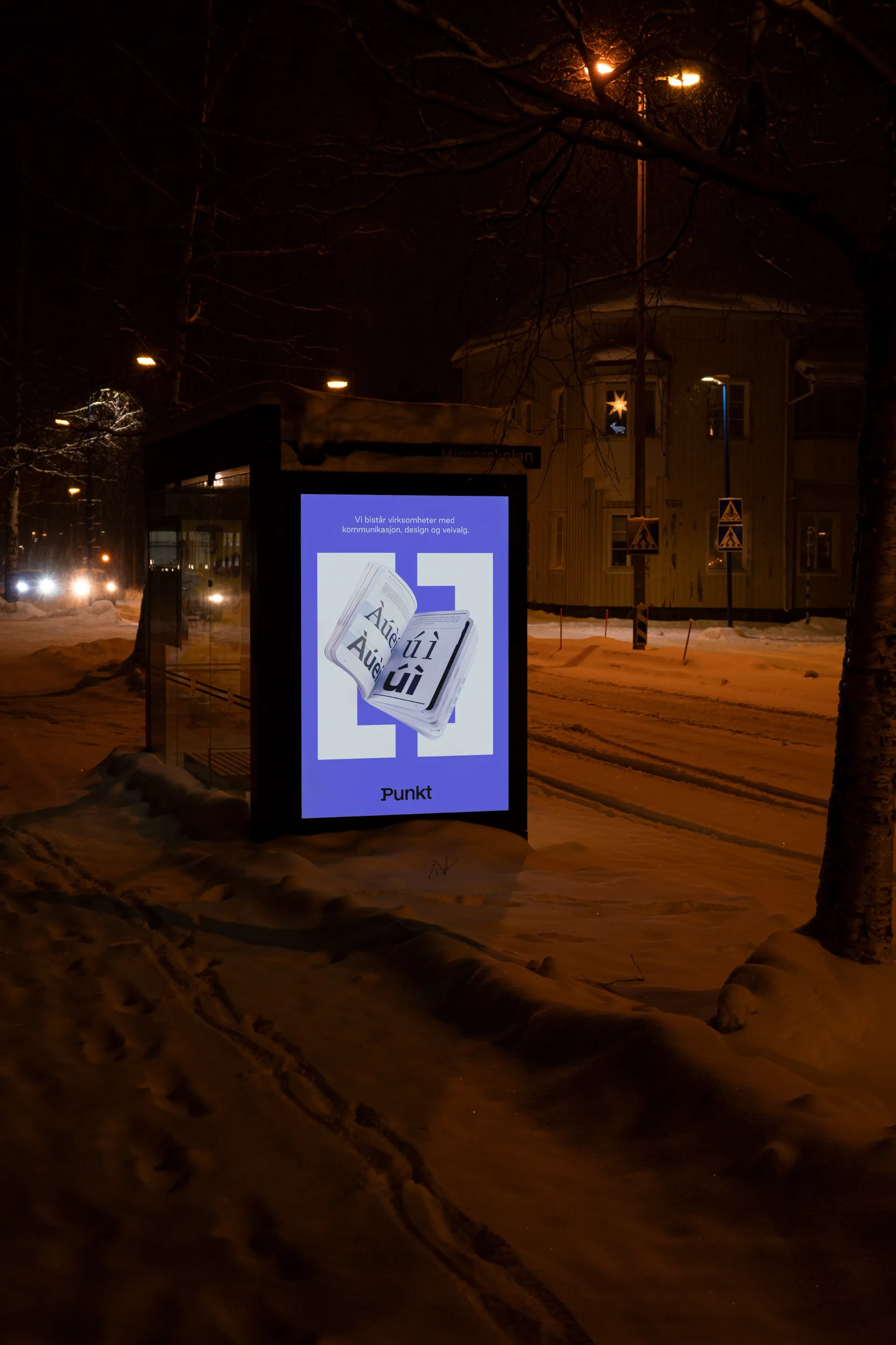 En Punkt-plakat i et busskur en snøfull kveld