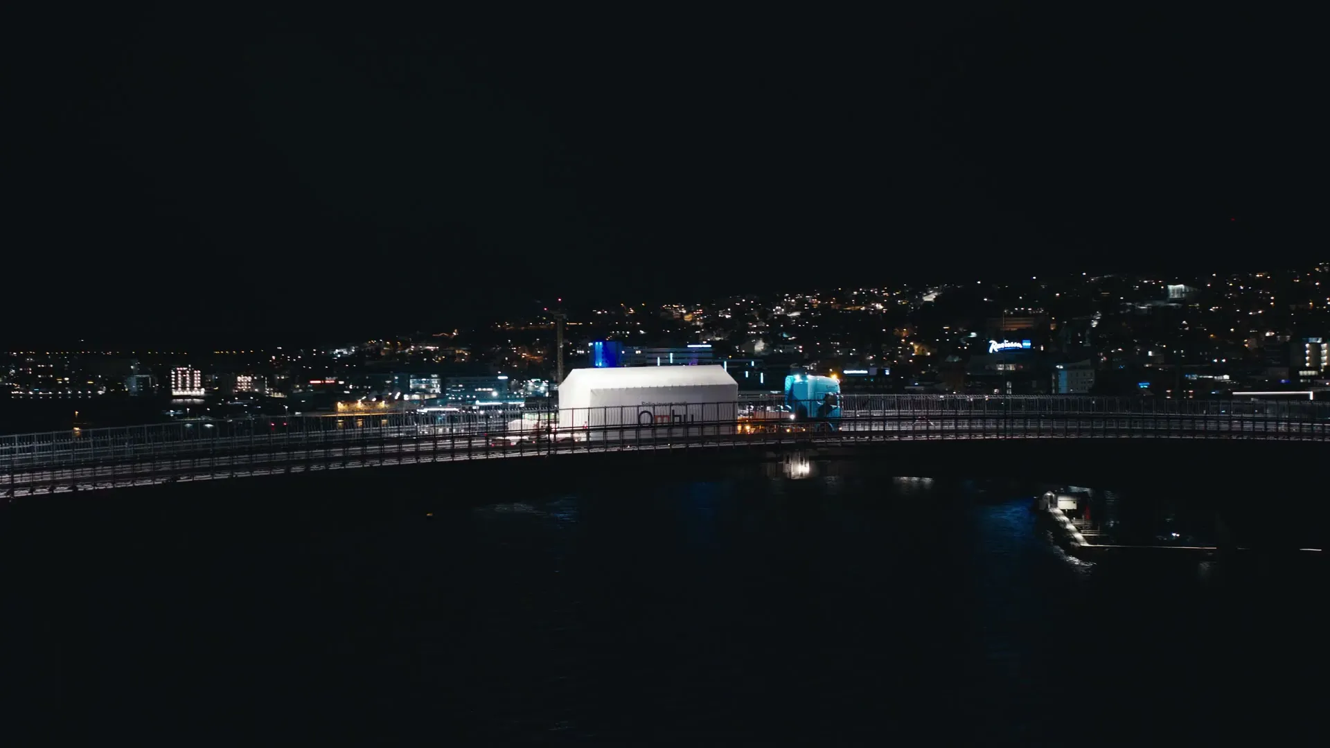 A city by a bridge at night, seen from above
